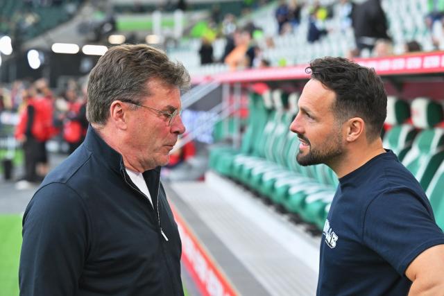 21 May 2026, Lower Saxony, Wolfsburg: VfL Wolfsburg coach Dieter Hecking (L) and Paderborn coach Ralf Kettemann (R) talk ahead of the German Bundesliga relegation playoff soccer match between VfL Wolfsburg and SC Paderborn 07 at Volkswagen Arena. Photo: Swen Pförtner/dpa - WICHTIGER HINWEIS: Gemäß den Vorgaben der DFL Deutsche Fußball Liga bzw. des DFB Deutscher Fußball-Bund ist es untersagt, in dem Stadion und/oder vom Spiel angefertigte Fotoaufnahmen in Form von Sequenzbildern und/oder videoähnlichen Fotostrecken zu verwerten bzw. verwerten zu lassen.