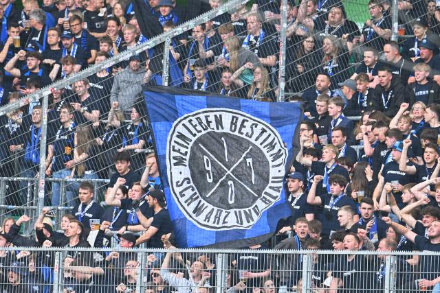 21 May 2026, Lower Saxony, Wolfsburg: A banner reading "My life is black and blue" can be seen in the stands ahead of the German Bundesliga relegation playoff soccer match between VfL Wolfsburg and SC Paderborn 07 at Volkswagen Arena. Photo: Swen Pförtner/dpa - WICHTIGER HINWEIS: Gemäß den Vorgaben der DFL Deutsche Fußball Liga bzw. des DFB Deutscher Fußball-Bund ist es untersagt, in dem Stadion und/oder vom Spiel angefertigte Fotoaufnahmen in Form von Sequenzbildern und/oder videoähnlichen Fotostrecken zu verwerten bzw. verwerten zu lassen.