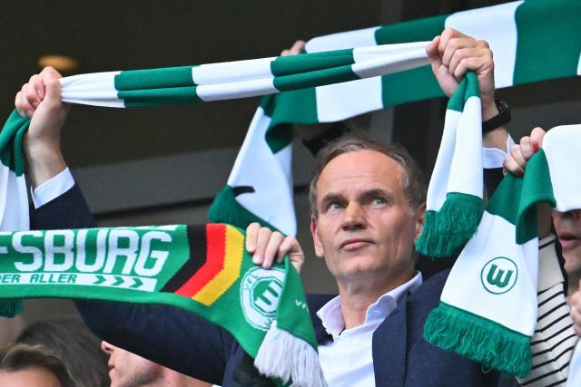 21 May 2026, Lower Saxony, Wolfsburg: VW CEO Oliver Blume waves a Wolfsburg scarf from the stands during the German Bundesliga relegation playoff soccer match between VfL Wolfsburg and SC Paderborn 07 at Volkswagen Arena. Photo: Swen Pförtner/dpa - WICHTIGER HINWEIS: Gemäß den Vorgaben der DFL Deutsche Fußball Liga bzw. des DFB Deutscher Fußball-Bund ist es untersagt, in dem Stadion und/oder vom Spiel angefertigte Fotoaufnahmen in Form von Sequenzbildern und/oder videoähnlichen Fotostrecken zu verwerten bzw. verwerten zu lassen.