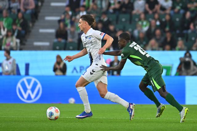 21 May 2026, Lower Saxony, Wolfsburg: Paderborn's Jonah Sticker (L) and Wolfsburg's Saeal Kumbedi (R) battle for the ball during the German Bundesliga relegation playoff soccer match between VfL Wolfsburg and SC Paderborn 07 at Volkswagen Arena. Photo: Swen Pförtner/dpa - WICHTIGER HINWEIS: Gemäß den Vorgaben der DFL Deutsche Fußball Liga bzw. des DFB Deutscher Fußball-Bund ist es untersagt, in dem Stadion und/oder vom Spiel angefertigte Fotoaufnahmen in Form von Sequenzbildern und/oder videoähnlichen Fotostrecken zu verwerten bzw. verwerten zu lassen.