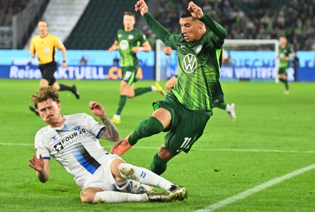 21 May 2026, Lower Saxony, Wolfsburg: Wolfsburg's Adam Daghim (R) Paderborn's Calvin Brackelmann (L) battle for the ball during the German Bundesliga relegation playoff soccer match between VfL Wolfsburg and SC Paderborn 07 at Volkswagen Arena. Photo: Swen Pförtner/dpa - WICHTIGER HINWEIS: Gemäß den Vorgaben der DFL Deutsche Fußball Liga bzw. des DFB Deutscher Fußball-Bund ist es untersagt, in dem Stadion und/oder vom Spiel angefertigte Fotoaufnahmen in Form von Sequenzbildern und/oder videoähnlichen Fotostrecken zu verwerten bzw. verwerten zu lassen.