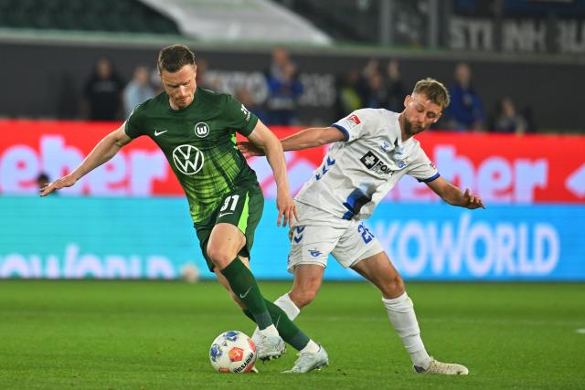21 May 2026, Lower Saxony, Wolfsburg: Wolfsburg's Yannick Gerhardt (L) Paderborn's Sebastian Klaas (R) battle for the ball during the German Bundesliga relegation playoff soccer match between VfL Wolfsburg and SC Paderborn 07 at Volkswagen Arena. Photo: Swen Pförtner/dpa - WICHTIGER HINWEIS: Gemäß den Vorgaben der DFL Deutsche Fußball Liga bzw. des DFB Deutscher Fußball-Bund ist es untersagt, in dem Stadion und/oder vom Spiel angefertigte Fotoaufnahmen in Form von Sequenzbildern und/oder videoähnlichen Fotostrecken zu verwerten bzw. verwerten zu lassen.