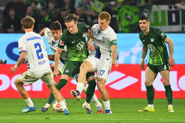 21 May 2026, Lower Saxony, Wolfsburg: Wolfsburg's Mattias Svanberg (C) Paderborn's Laurin Curda (Center Right) battle for the ball during the German Bundesliga relegation playoff soccer match between VfL Wolfsburg and SC Paderborn 07 at Volkswagen Arena. Photo: Swen Pförtner/dpa - WICHTIGER HINWEIS: Gemäß den Vorgaben der DFL Deutsche Fußball Liga bzw. des DFB Deutscher Fußball-Bund ist es untersagt, in dem Stadion und/oder vom Spiel angefertigte Fotoaufnahmen in Form von Sequenzbildern und/oder videoähnlichen Fotostrecken zu verwerten bzw. verwerten zu lassen.