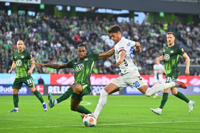 21 May 2026, Lower Saxony, Wolfsburg: Paderborn's Stefano Marino (R) shoots past Wolfsburg's Jeanuel Belocian (L) during the German Bundesliga relegation playoff soccer match between VfL Wolfsburg and SC Paderborn 07 at Volkswagen Arena. Photo: Swen Pförtner/dpa - WICHTIGER HINWEIS: Gemäß den Vorgaben der DFL Deutsche Fußball Liga bzw. des DFB Deutscher Fußball-Bund ist es untersagt, in dem Stadion und/oder vom Spiel angefertigte Fotoaufnahmen in Form von Sequenzbildern und/oder videoähnlichen Fotostrecken zu verwerten bzw. verwerten zu lassen.