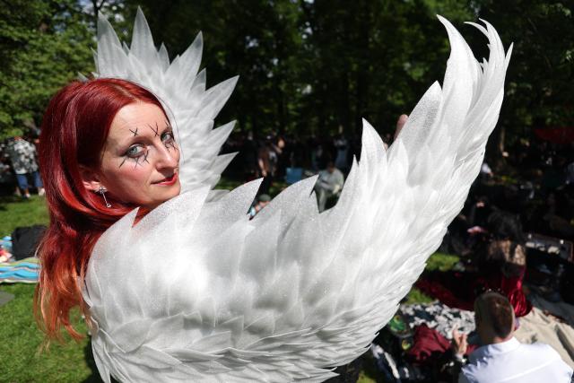 22 May 2026, Saxony, Leipzig: A visitor to the Wave-Gotik-Treffen poses in a costume with white wings. Up to 20,000 guests from Germany and abroad are expected to attend the 33rd edition of the festival. Over the Pentecost weekend, the event will feature around 200 bands and cultural events, ranging from picnics in parks to concerts in churches and cemeteries. Photo: Jan Woitas/dpa