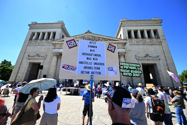 23 May 2026, Bavaria, Munich: Demonstrators stand in front of the Propylaea holding a sign reading, "Now we can find out what we would have done in our grandparents' place," during the nationwide day of action titled "Defend Human Dignity-Ban the AfD Now!". Photo: Felix Hörhager/dpa