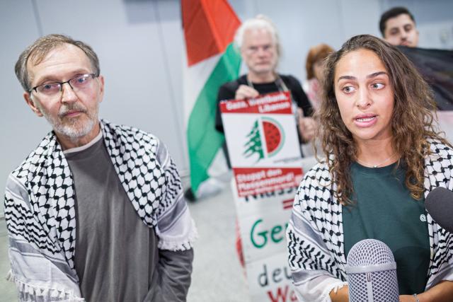 23 May 2026, Lower Saxony, Langenhagen: Uwe Sander and Nesrin Zeaiter give interviews while standing in front of their supporters at Hanover Airport. The two activists from the Gaza aid flotilla, who were deported from Israel to Turkey, have returned to Germany. Photo: Moritz Frankenberg/dpa