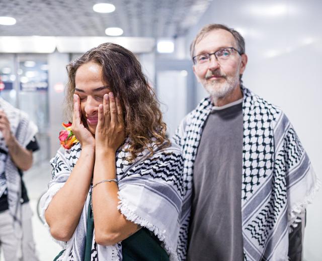 23 May 2026, Lower Saxony, Langenhagen: Uwe Sander and Nesrin Zeaiter give interviews while standing in front of their supporters at Hanover Airport. The two activists from the Gaza aid flotilla, who were deported from Israel to Turkey, have returned to Germany. Photo: Moritz Frankenberg/dpa