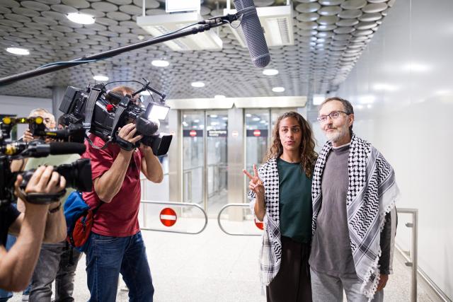 23 May 2026, Lower Saxony, Langenhagen: Nesrin Zeaiter and Uwe Sander stand in front of their supporters at Hannover Airport. The two activists from the Gaza aid flotilla, who had been deported from Israel to Turkey, have returned to Germany. Photo: Moritz Frankenberg/dpa