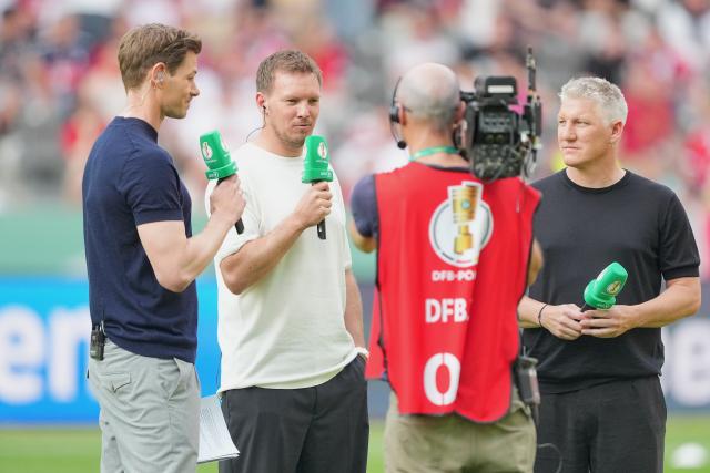 23 May 2026, Berlin: Germany National Team Coach Julian Nagelsmann (2nd L) stands with Alexander Schlueter, host (L), and Bastian Schweinsteiger (R), former national team player and TV analyst, ahead of the German DFB Cup Final soccer match between Bayern Munich and VfB Stuttgart at Berlin Olympic Stadium. Photo: Michael Kappeler/dpa