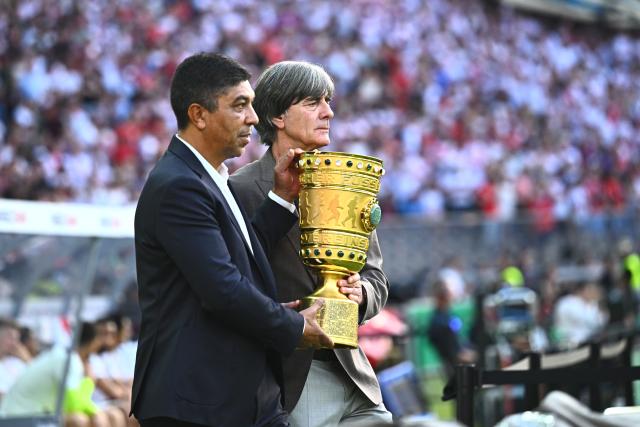 23 May 2026, Berlin: Former Germany's national team coach Joachim Loew (R) and Giovane Elber, a former Brazilian soccer player, enter the stadium carrying the trophy ahead of the German DFB Cup Final soccer match between Bayern Munich and VfB Stuttgart at Berlin Olympic Stadium. Photo: Tom Weller/dpa