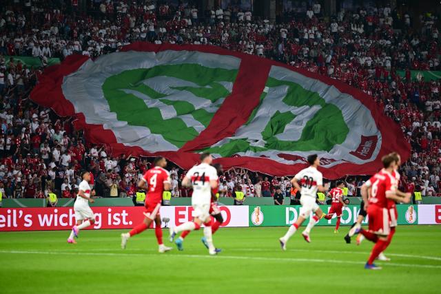 23 May 2026, Berlin: Fans hold up a large protest banner during the German DFB Cup Final between Bayern Munich and VfB Stuttgart at the Olympic Stadium in Berlin. Photo: Sebastian Gollnow/dpa