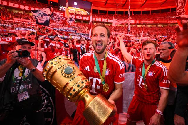 23 May 2026, Berlin: Bayern Munich's Harry Kane (L) and Bayern Munich's Joshua Kimmich celebrate with the trophy after winning the German DFB Cup Final against VfB Stuttgart at the Olympic Stadium in Berlin. Photo: Tom Weller/dpa