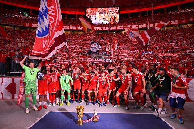 23 May 2026, Berlin: Bayern Munich players celebrate with the trophy after winning the German DFB Cup Final against VfB Stuttgart at the Olympic Stadium in Berlin. Photo: Tom Weller/dpa