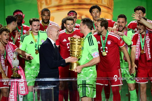 23 May 2026, Berlin: Kai Wegner, Governing Mayor of Berlin, presents the trophy to goalkeeper Bayern Munich's Manuel Neuer after the German DFB Cup Final between Bayern Munich vs VfB Stuttgart at the Olympic Stadium in Berlin. Photo: Sebastian Gollnow/dpa