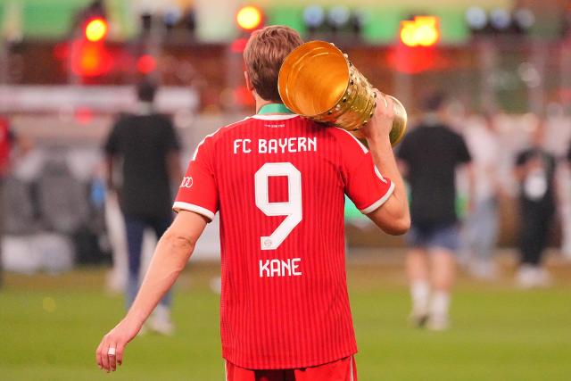 23 May 2026, Berlin: Bayern Munich's Harry Kane walks across the field with the trophy on his shoulder after winning the German DFB Cup Final against VfB Stuttgart at the Olympic Stadium in Berlin. Photo: Michael Kappeler/dpa