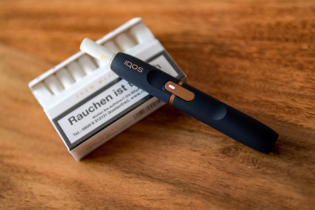 FILED - 13 November 2018, Hamburg: FILE PHOTO - A Philip Morris iqos e-cigarette lies on the counter of a tobacco shop. Photo: Axel Heimken/dpa