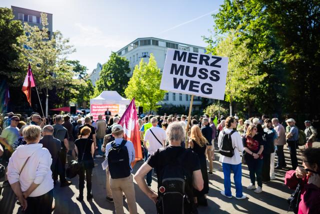 28 May 2026, Berlin: 'Merz must go' is written on a poster at a rally organized by the Sahra Wagenknecht Alliance (BSW) at Lucie-Leydicke-Platz in Berlin-Schoeneberg. Ahead of the Berlin House of Representatives election on September 20, 2026, the BSW is holding a rally and inviting attendees to join party founder Wagenknecht for a visit to a local pub. Photo: Christoph Soeder/dpa