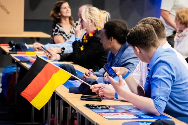 30 May 2026, Brandenburg, Brandenburg an der Havel: A party member holds a German national flag during the Alternative for Germany (AfD) Berlin state party conference. Delegates gathered at the venue to vote on the party's election manifesto for the upcoming state elections. Photo: Christoph Soeder/dpa