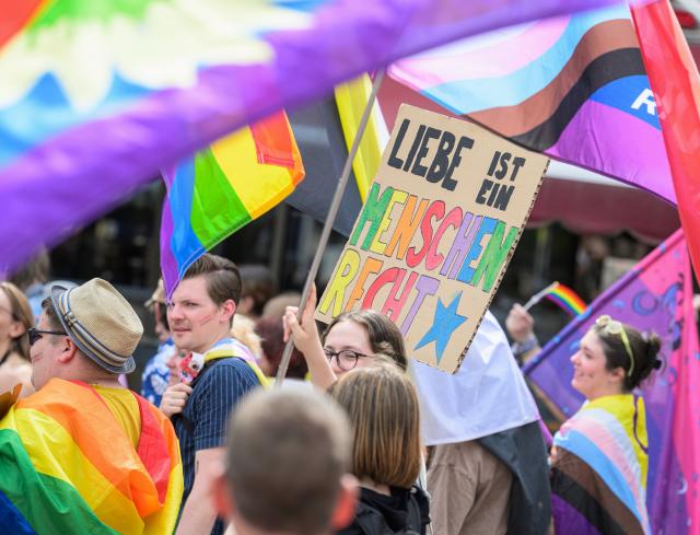 30 May 2026, Hesse, Wiesbaden: Protesters hold a sign reading "Love is a human right" during the Christopher Street Day event in Wiesbaden. According to the organizers, the group "Warmes Wiesbaden" plans to use Saturday's Pride event to stand up for an open society and against discrimination and anti-queer sentiment. Photo: Hannes P. Albert/dpa
