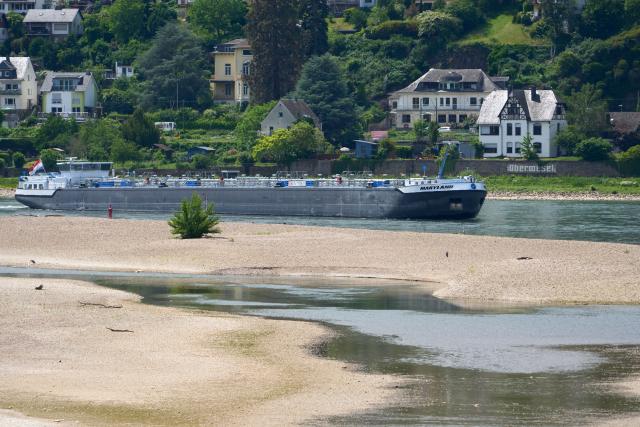 01 June 2026, Rheinland-Pfalz, Oberwesel: A cargo ship is passing a shoal in the Rhine near Oberwesel. High temperatures over the past few days have caused water levels to drop. Photo: Thomas Frey/dpa