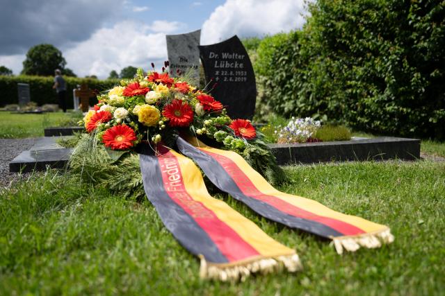 01 June 2026, Hesse, Wolfhagen-Istha: A wreath laid by German Chancellor Friedrich Merz lies at the grave of Walter Luebcke, regional governor of Kassel who was murdered in 2019, at the cemetery in Istha. Photo: Florian Wiegand/dpa