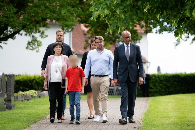 01 June 2026, Hesse, Wolfhagen-Istha: German Chancellor Friedrich Merz (R) and Irmgard Braun-Luebcke walk to the cemetery in Istha to lay a wreath at the grave of Walter Luebcke, regional governor of Kassel who was murdered in 2019. Photo: Florian Wiegand/dpa