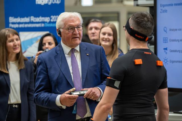 03 June 2026, Saarland, ---: German President Frank-Walter (C) speaks with an employee wearing sensors during a visit to the Hager company. Photo: Harald Tittel/dpa
