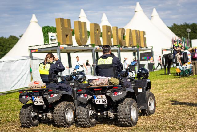 FILED - 20 June 2024, Lower Saxony, Scheeßel: FILE PHOTO - Police officers patrol the grounds on quad bikes. Photo: Moritz Frankenberg/dpa