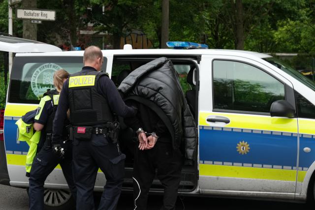 03 June 2026, Berlin: Berlin police lead a man away in handcuffs in Hellersdorf after a man who was reportedly seen with a weapon was arrested there. A resident of an apartment building informed police that he had seen a man with a weapon, who then returned to his apartment on Oschatzer Ring. Photo: Sven Kaeuler/dpa