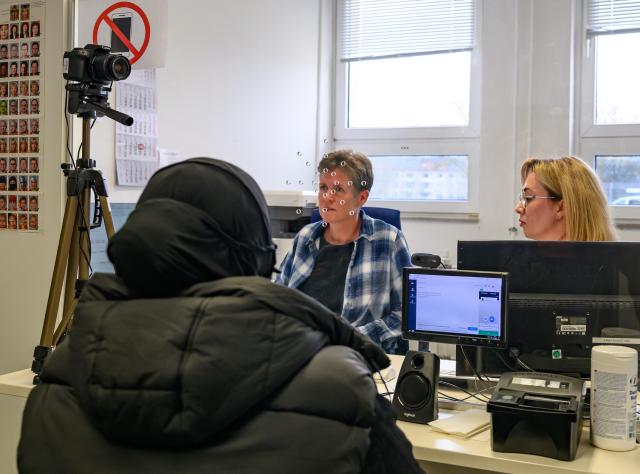 FILED - 13 March 2025, Brandenburg, Eisenhuettenstadt: FILE PHOTO - A refugee woman (L) from the Russian Federation, who entered Germany via Poland, is registered by employees at the Brandenburg Central Aliens Office (ZABH) for identification purposes. Photo: Patrick Pleul/dpa