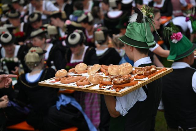04 June 2026, Bavaria, Wackersberg: Sausages are brought to the tables after the Corpus Christi procession at the beer garden. Photo: Sven Hoppe/dpa