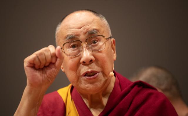 FILED - 20 September 2018, Baden-Wuerttemberg, Heidelberg: Dalai Lama, highest spiritual leader and head of Tibetan Buddhism, clenches his fist during his farewell words at an event in Heidelberg. Photo: Marijan Murat/dpa