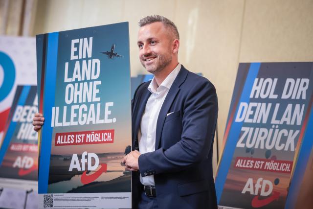 04 June 2026, Saxony-Anhalt, Magdeburg: Ulrich Siegmund, top candidate of the AfD Saxony-Anhalt, presents AfD posters during a press conference to present the election campaign for the state election. Photo: Ronny Hartmann/dpa