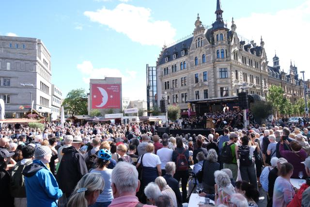 05 June 2026, Saxony-Anhalt, Bernburg: Music lovers watch a performance by the Academic Orchestra of Martin Luther University Halle-Wittenberg on a stage in the market square. The occasion is the opening of the Handel Festival, which will be held in the city on the Saale from June 5 to 14, 2026. Photo: Sebastian Willnow/dpa