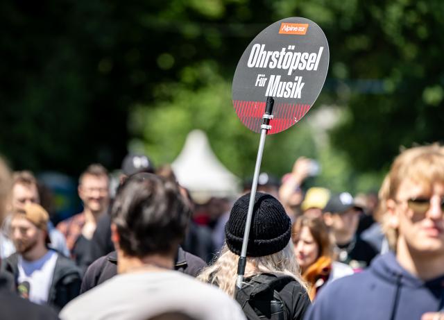 05 June 2026, Bavaria, Nuremberg: 'Earplugs for music' is written on a sign held by a staff member at the Rock im Park open-air festival. Photo: Daniel Karmann/dpa