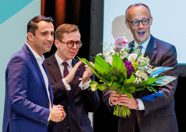 06 June 2026, Mecklenburg-Western Pomerania, Linstow: German Chancellor Friedrich Merz receives a bouquet of flowers from Daniel Peters (L), state leader of the CDU in Mecklenburg-Vorpommern, and Philipp Amthor (C), Parliamentary State Secretary in the Ministry of Digital Affairs the state party during the state conference of the Christian Democratic Union (CDU) Mecklenburg-Western Pomerania. Photo: Jens Büttner/dpa