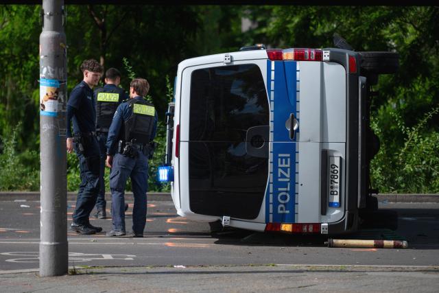 06 June 2026, Berlin: An overturned police car is lying on the road. Eight people were injured in a collision between a taxi and a police car, two of them seriously. Photo: Christophe Gateau/dpa