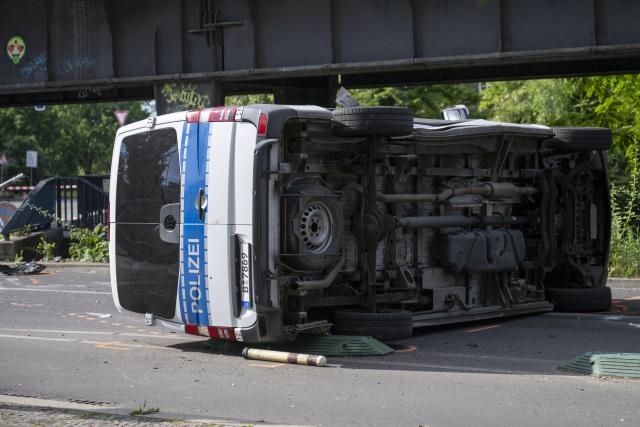 06 June 2026, Berlin: An overturned police car is lying on the road. Eight people were injured in a collision between a taxi and a police car, two of them seriously. Photo: Christophe Gateau/dpa