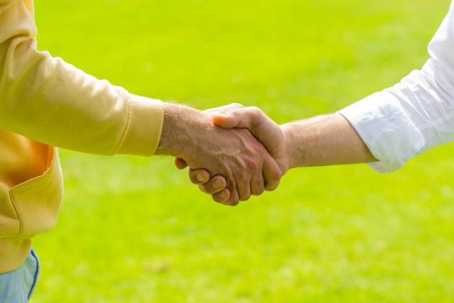 PRODUCTION - 03 July 2021, Lower Saxony, Oldenburg: Two men shake hands in greeting. Photo: Mohssen Assanimoghaddam/dpa