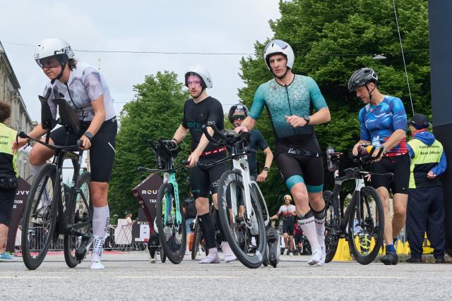 07 June 2026, Hamburg: Participants in the Everyman race mount their bicycles after exiting the transition zone during the Ironman triathlon competition. Photo: Georg Wendt/dpa