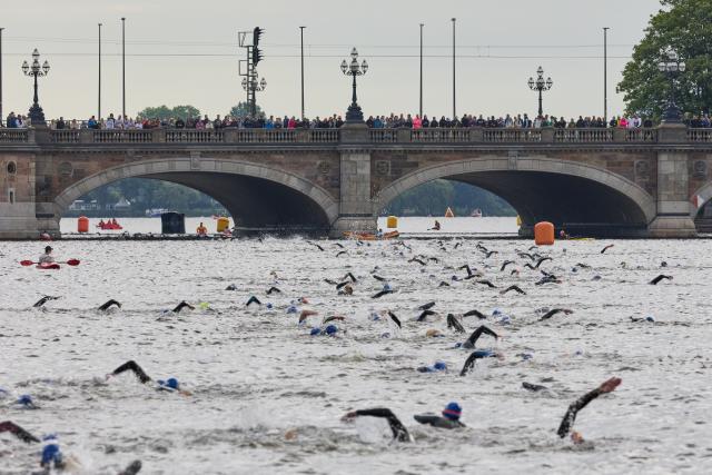 07 June 2026, Hamburg: Competitors swim through the Binnenalster lake past the Lombardsbruecke bridge after the start of the Ironman European Championship triathlon. Photo: Georg Wendt/dpa