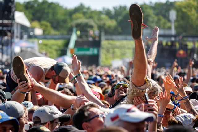07 June 2026, Rhineland-Palatinate, Nuremberg: Visitors at the Rock im Park open-air festival are carried over the crowd on the hands of other concertgoers. Photo: Daniel Karmann/dpa