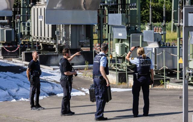 08 June 2026, Baden-Württemberg, Reutlingen: Police officers stand on the site of a power substation in Reutlingen, following a suspected overnight arson attack. The late-night fire at the facility caused a widespread power outage that left around 20,000 households and local hospitals temporarily without electricity, triggering a large-scale investigation by state criminal authorities. Photo: Christoph Schmidt/dpa