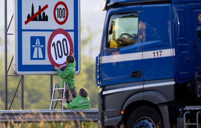 08 June 2026, Bavaria, Kiefersfelden: Greenpeace activists hang a banner mimicking a speed limit sign over a highway marker along the Autobahn 93 (A93) near Regentauf, Germany. The environmental organization staged the morning demonstration to demand the immediate implementation of a permanent, nationwide speed limit on the German highway network to curb carbon emissions. Photo: Sven Hoppe/dpa