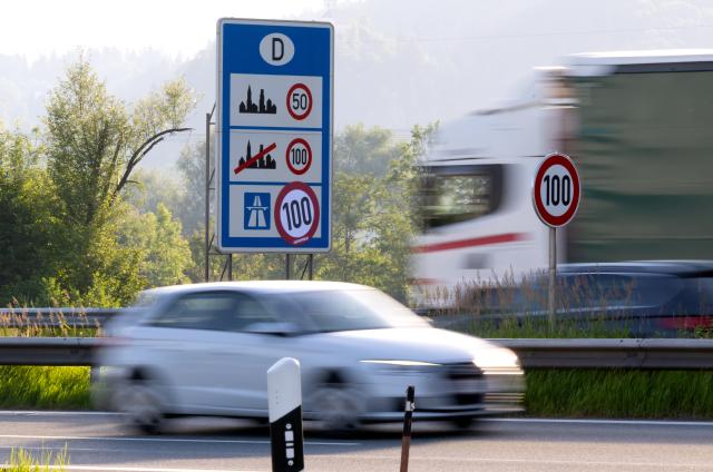 08 June 2026, Bavaria, Kiefersfelden: A car drives past a highway sign that Greenpeace activists covered with a mock "100" speed limit banner along the Autobahn 93 (A93) near Regentauf, Germany. The environmental group staged the demonstration to advocate for a nationwide highway speed limit to reduce carbon emissions. Photo: Sven Hoppe/dpa