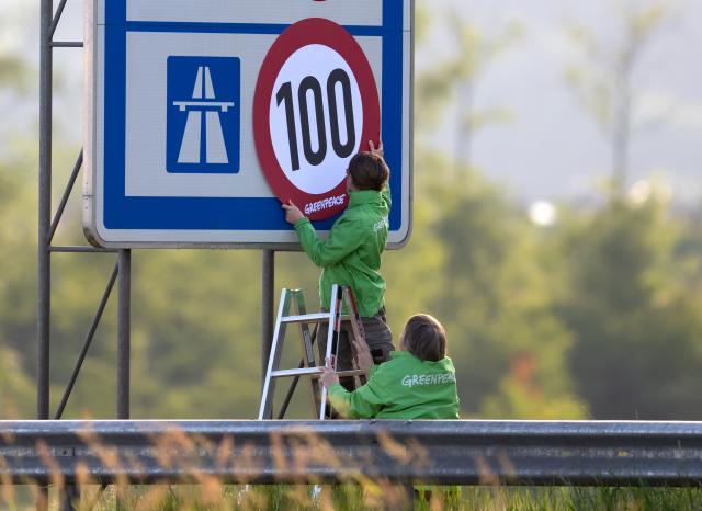 08 June 2026, Bavaria, Kiefersfelden: Greenpeace activists hang a banner mimicking a speed limit sign over a highway marker along the Autobahn 93 (A93) near Regentauf, Germany. The environmental organization staged the morning demonstration to demand the immediate implementation of a permanent, nationwide speed limit on the German highway network to curb carbon emissions. Photo: Sven Hoppe/dpa