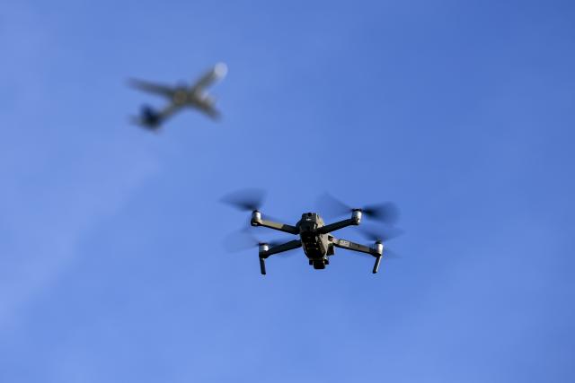 FILED - 05 November 2025, Saxony-Anhalt, Kabelsketal: A drone flies in front of an aircraft taking off near Leipzig/Halle Airport. Photo: Jan Woitas/dpa