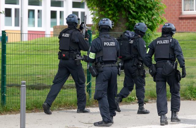 08 June 2026, North Rhine-Westphalia, Bochum: Armed police officers stand guard outside a school in Bochum, Germany, following a security threat. Authorities deployed heavily armed tactical units to secure the building and evacuate students as a precautionary measure while an investigation into the incident is conducted. Photo: Bernd Thissen/dpa