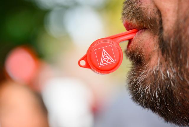 FILED - 12 September 2022, Hannover: An employee stands in front of a hotel with an IG Metall whistle. Photo: Julian Stratenschulte/dpa
